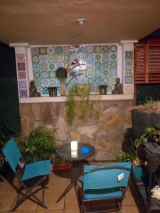 un patio con sillas, una mesa y una pared en Hostal La Casa del Puente, en Santiago