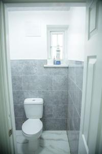 a bathroom with a white toilet and a window at 5 bedroom semi-detached house- 3 double beds - 2 single beds in Birmingham