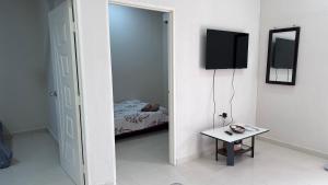 Cette chambre comprend un miroir, un lit et une table. dans l'établissement Homestay Mama, Kubang Kerian, à Kota Bharu