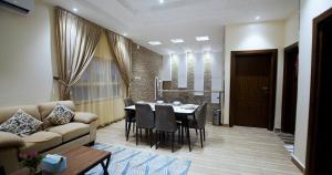 a living room with a couch and a table and chairs at شاليهات وفلل ريلاكس بلاس in Sirr Āl Ghalīz̧