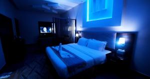 a blue room with a bed with a blue light at شاليهات وفلل ريلاكس بلاس in Sirr Āl Ghalīz̧ +25 photos