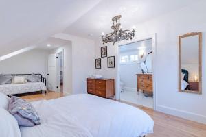 a white bedroom with a bed and a mirror at Elegant Elora Home with Stylish Décor in Elora