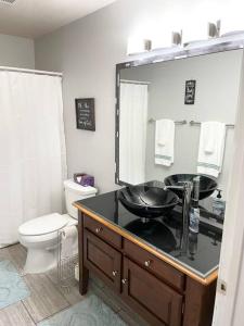 a bathroom with a sink and a toilet and a mirror at Luxury Family Condo w/ Great Views & Entertainment in Branson