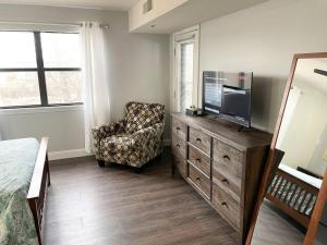 a bedroom with a dresser with a tv and a chair at Luxury Family Condo w/ Great Views & Entertainment in Branson