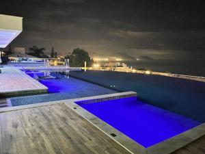 una piscina por la noche con iluminación azul en Apartamento fantástico, piscina vista mar, en Florianópolis