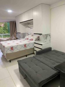 a bedroom with a bed and a desk in it at Flat Beira Mar Carapibus in Conde