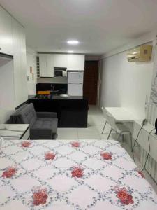 a small room with a bed and a kitchen at Flat Beira Mar Carapibus in Conde