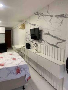 a bedroom with a bed and a tv on a wall at Flat Beira Mar Carapibus in Conde +15 photos