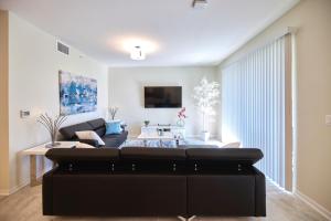 ein Wohnzimmer mit einem Sofa und einem Tisch in der Unterkunft Vacation Meadows - Storey Lake by Shine Villas 710 apts in Kissimmee