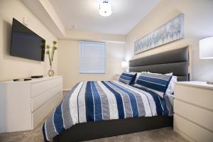 Schlafzimmer mit einem Bett und einem Flachbild-TV in der Unterkunft Vacation Meadows - Storey Lake by Shine Villas 710 apts in Kissimmee