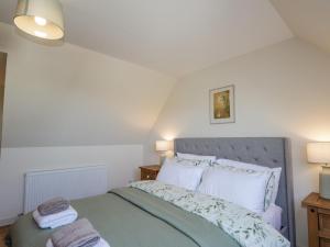 1 dormitorio con 1 cama con 2 toallas en East Balachladich en Muir of Ord