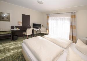 ein Hotelzimmer mit 2 Betten und einem Schreibtisch in der Unterkunft Land-gut-Hotel Rohdenburg in Lilienthal