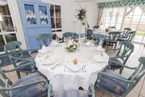 ein Esszimmer mit einem weißen Tisch und Stühlen in der Unterkunft Land-gut-Hotel Rohdenburg in Lilienthal