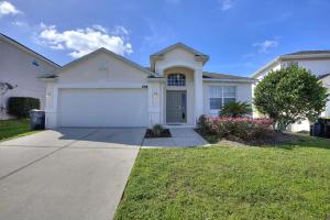 a white house with a garage in a yard at Sun Living- Golf Community, Private Pool 809 villa in Davenport