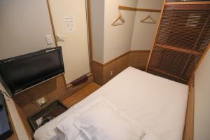 a small room with a bed and a flat screen tv at プチホテル　コスモス in Tokyo