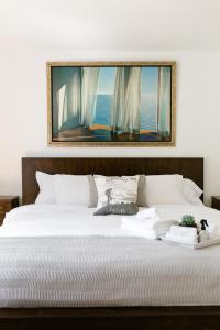 een groot wit bed met een foto erboven bij 3BR, 2 bath w/ HOT TUB on private view balcony & AC in Crescent Valley