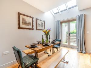 a dining room with a wooden table and chairs at Nixey Cottage in Turville