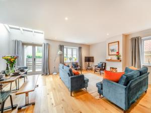 uma sala de estar com dois sofás azuis e uma mesa em Nixey Cottage em Turville