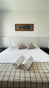 1 cama blanca grande con 2 toallas en Casa em Floripa - 200m da praia, en Florianópolis