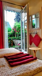 a bed with red pillows on it in front of a window at Appartementhaus Grill in Strobl