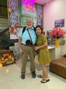 a man and a woman posing for a picture in a store at MyMy Motel in Da Nang