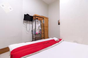 a bedroom with a bed with a red blanket on it at RedDoorz near Hang Nadim Batam Airport in Nongsa