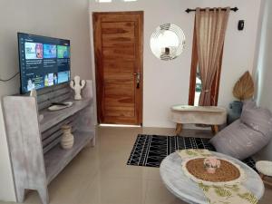 a living room with a tv and a couch and a table at rindoe jogja holiday home in Yogyakarta