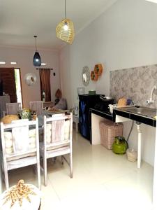 a kitchen with a table and some chairs in a room at rindoe jogja holiday home in Yogyakarta