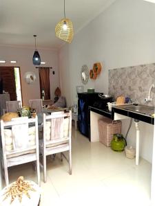 cocina con mesa y algunas sillas en una habitación en rindoe jogja holiday home en Yogyakarta