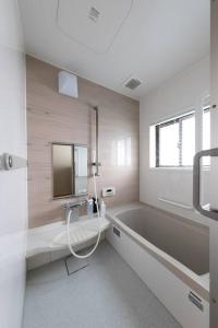 La salle de bains est pourvue d'une baignoire, d'un lavabo et d'un miroir. dans l'établissement あぽろん, à Gujō