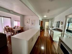 uma cozinha com um balcão branco e uma sala de jantar em Seacrest on Bright em Emu Park