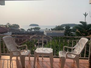 two chairs and a table on a balcony at Da Bungalows in Kata Beach