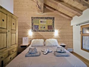 ein Schlafzimmer mit einem Bett mit Handtüchern und Schuhen darauf in der Unterkunft Chalet authentique avec sauna et hammam à Saint-Martin-de-Belleville - FR-1-613B-10 in Saint-Marcel