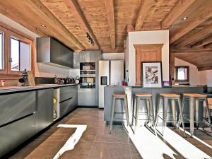 a kitchen with wooden ceilings and a bar with stools at Chalet Les Menuires, 7 pièces, 10 personnes - FR-1-613B-12 in Levassaix