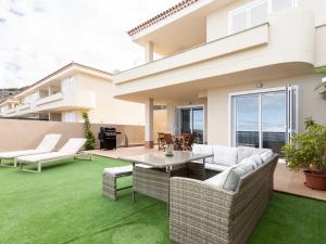 une arrière-cour avec une pelouse verdoyante et une maison dans l'établissement Apartamento Tenerife, 1 dormitorio, 2 personas - ES-279-9, à Puerto de Santiago