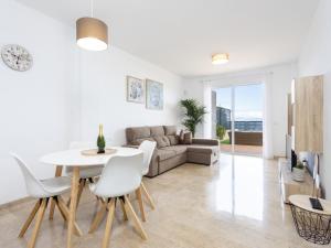 un soggiorno con un divano, un tavolo e delle sedie di Propiedad nueva con piscina, seguridad privada y vista al océano en Tenerife - ES-279-9 a Puerto de Santiago
