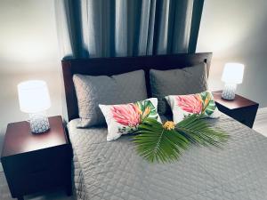 - une chambre avec un lit avec des oreillers et 2 lampes dans l'établissement Fare Luna - Comfy New home in Bora Bora, à Bora Bora