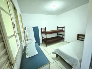 Zimmer mit einem Bett und einem Schreibtisch mit einem Ventilator in der Unterkunft Sonho meu in Guaratinguetá