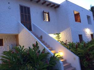 a white house with stairs in front of it at Vacaciones Playa Club Casa Blanca Same Esmeraldas in Same