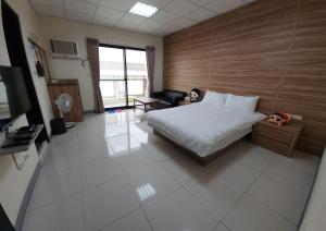 東港的住宿－宜家莊親子民宿，一间卧室配有一张床、一张沙发和一台电视