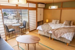 una camera con letto, tavolo e sedie di Elan Hotel Lake Nojiri a Shinano