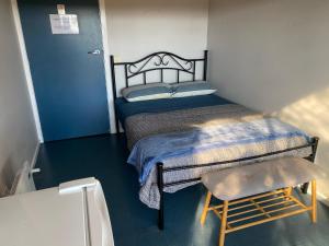 a small bedroom with a bed and a chair at 13th Apostle Accommodation in Princetown