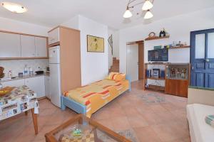 a living room with a bed and a kitchen at Icarus home in Kouniádhoi