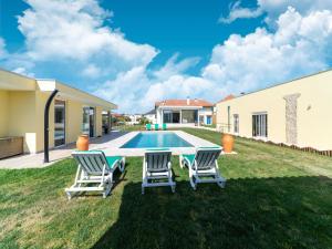 um quintal com duas cadeiras e uma piscina em Rural holiday home in Netos Almagreira with shared pool 