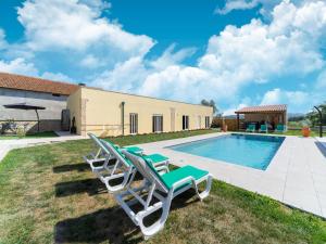 um par de cadeiras ao lado de uma piscina em Rural holiday home in Netos Almagreira with shared pool 