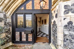 an open door into a room with a checkered floor at Butley Priory in Woodbridge