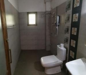 een badkamer met een wit toilet en een douche bij The Yala City Guest House in Tissamaharama