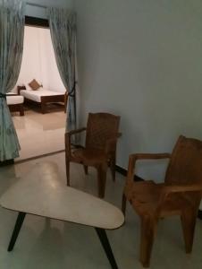 a living room with two chairs and a couch at The Yala City Guest House in Tissamaharama