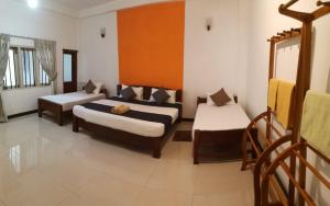 een kamer met 2 bedden en een bank. bij The Yala City Guest House in Tissamaharama