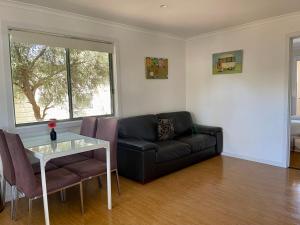 a living room with a black couch and a table at BIG4 Port Willunga Tourist Park in Aldinga